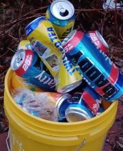 A bucket full of empty 25 oz beer cans