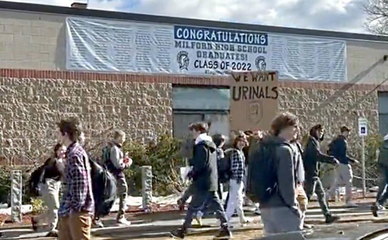 Milford students protesting with "We Want Urinals" sign