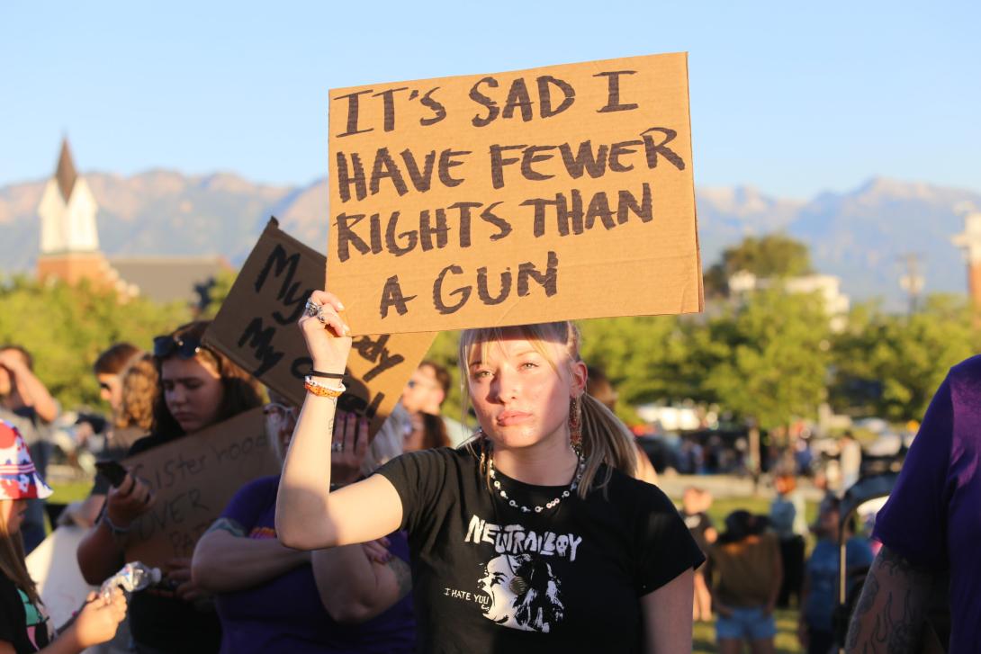 Woman with sign that reads "Is sad that I have fewer rights than a gun"