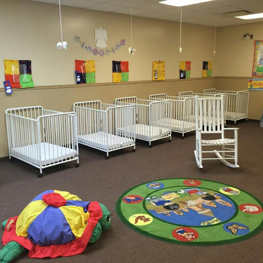 Child care room with cribs and toys